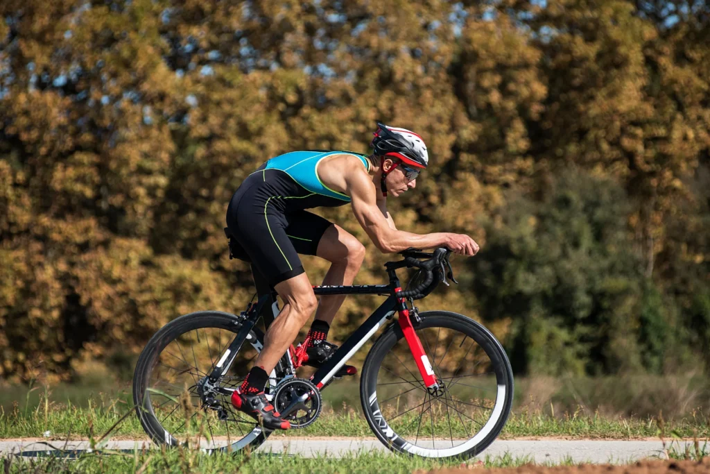 male cyclist rides bicycle on rural paved