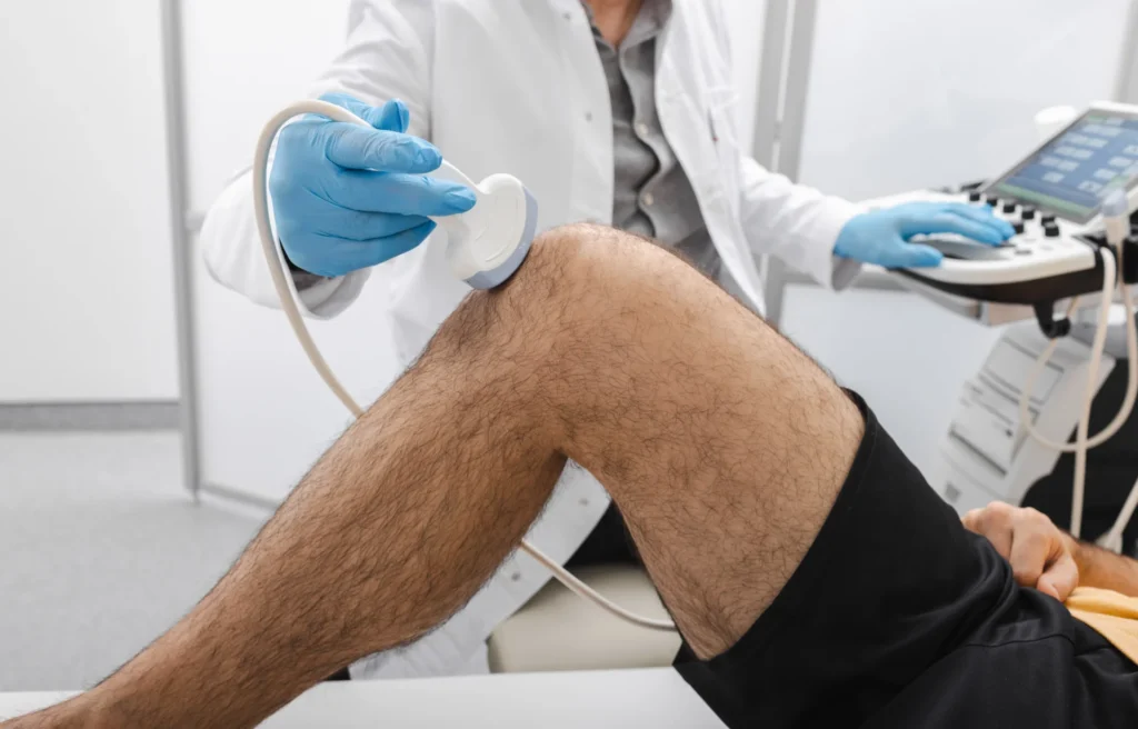 medical professional examines knee with ultrasound