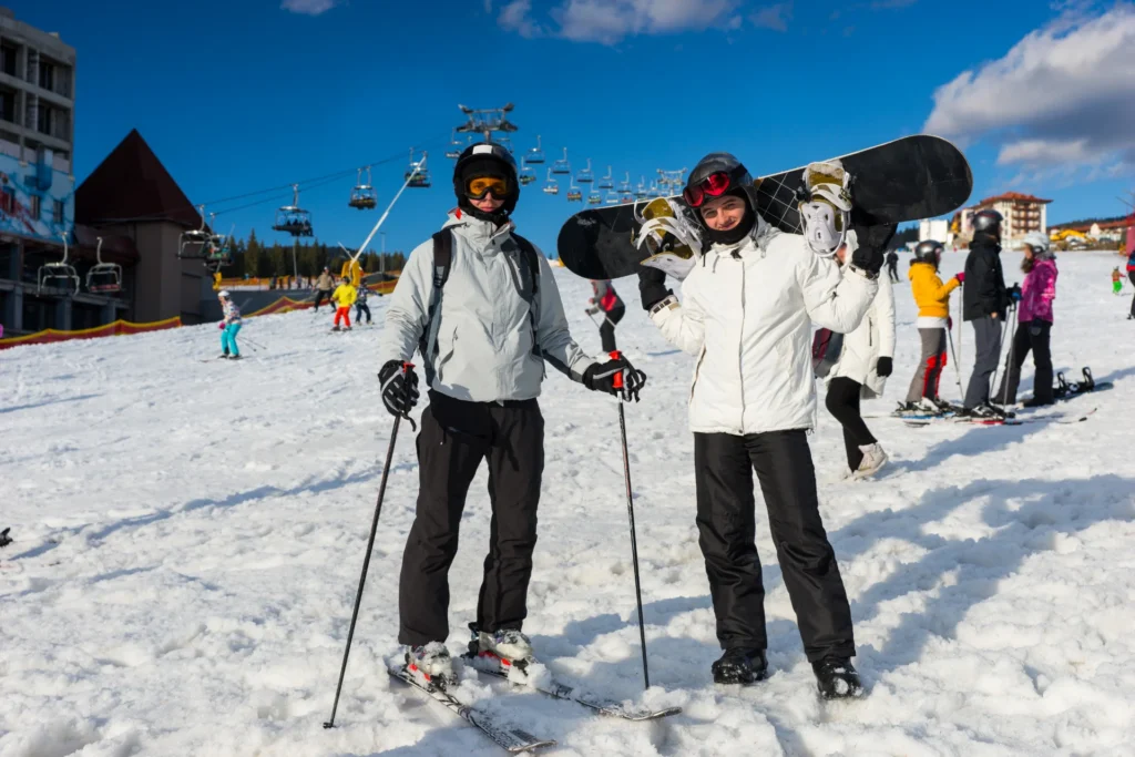 skiers and snowboarder enjoying sunny day in mount