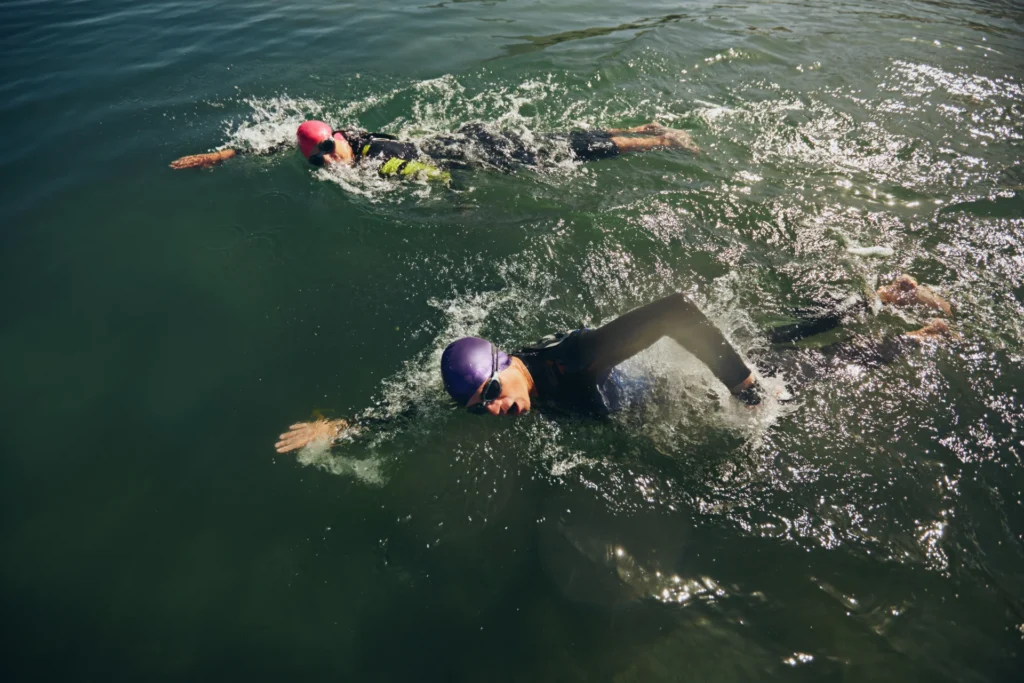 two swimmers stroke through blue water